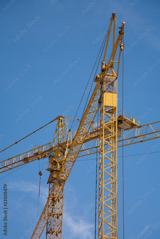 two construction cranes with sky as a background two construction cranes with sky as a background
