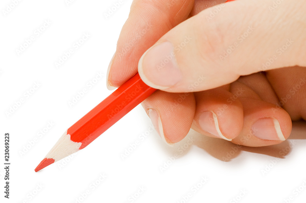 The hand holds a red pencil The hand holds a red pencil
