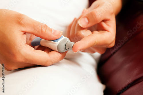 Frau testet Blutzucker auf Diabetes