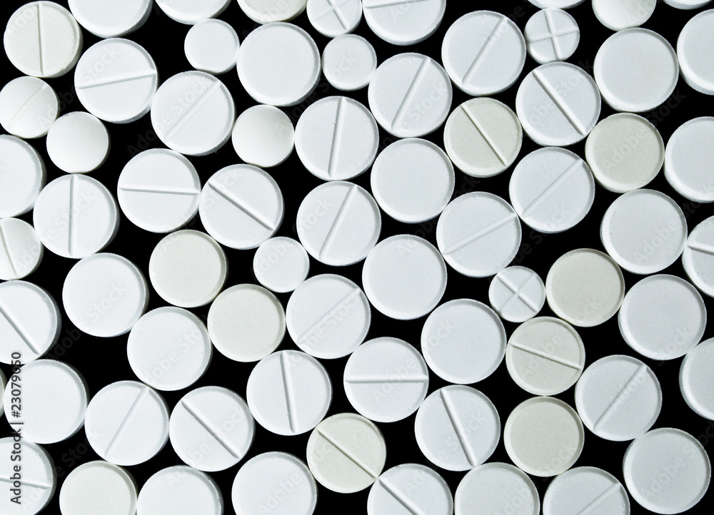White pills scattered on the black background. Top view White pills scattered on the black background. Top view