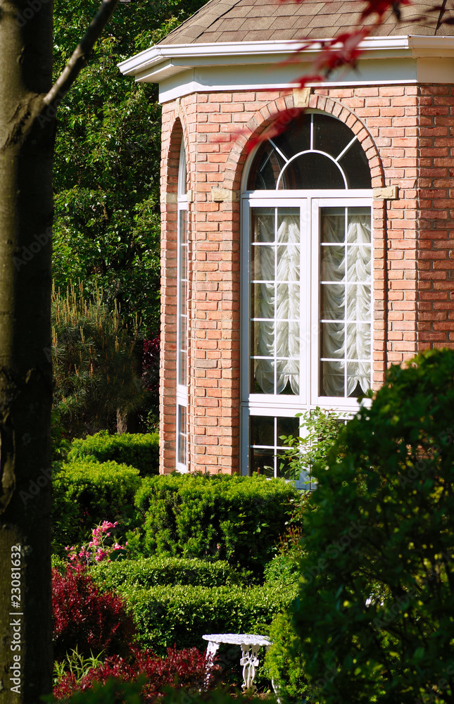 Fototapeta premium Bay window and garden of an upscale brick home