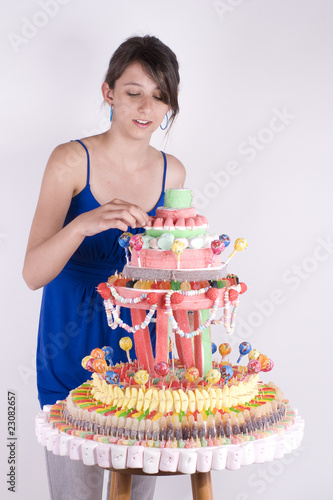 adolescente gourmande devant une pièce montée de bonbons photo