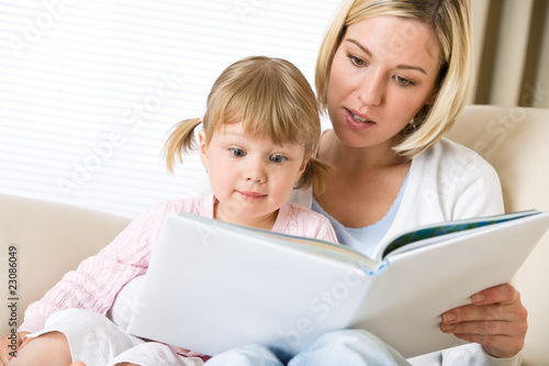 Mother with surprised little girl read book together