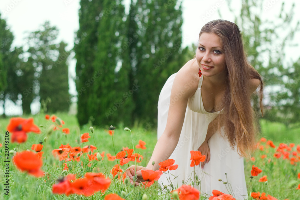 The smiling girl in the field with poppies