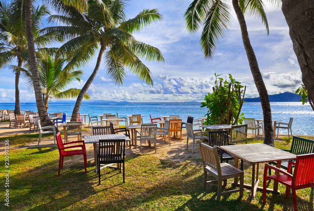 Cafe and palms on a tropical beach