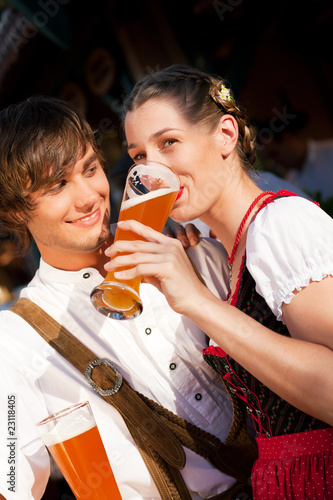 Paar in Tracht trinkt Weißbier