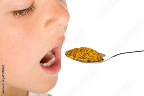 Little boy taking a spoonful of pollen - traditional remedies
