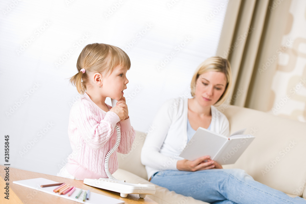 Mother and child - on the phone in living room Mother and child - on the phone in living room