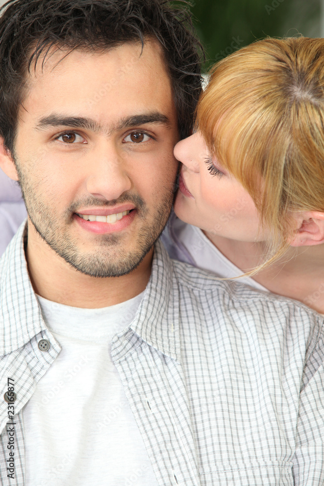 Jeune femme embrassant jeune homme sur la joue Jeune femme embrassant jeune homme sur la joue