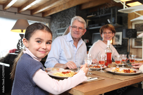 Fillette déjeunant avec ses grands-parents