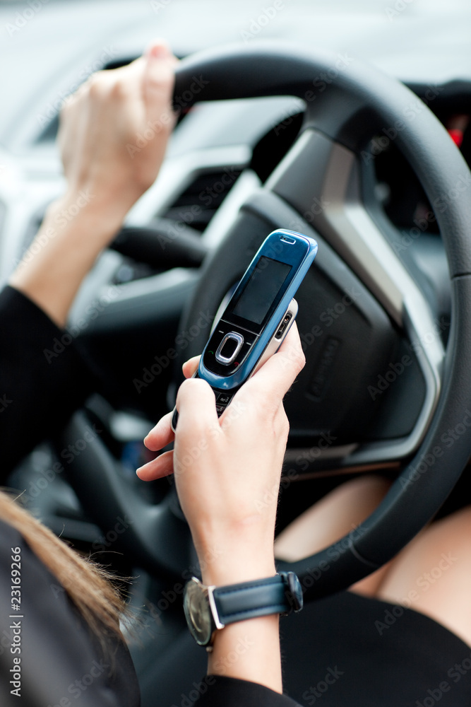 Close-up of a businesswoman sending a text while driving