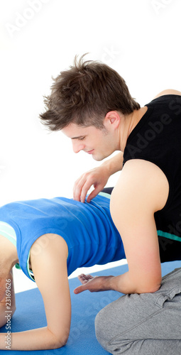 Caucasian woman working out assited by her personal trainer
