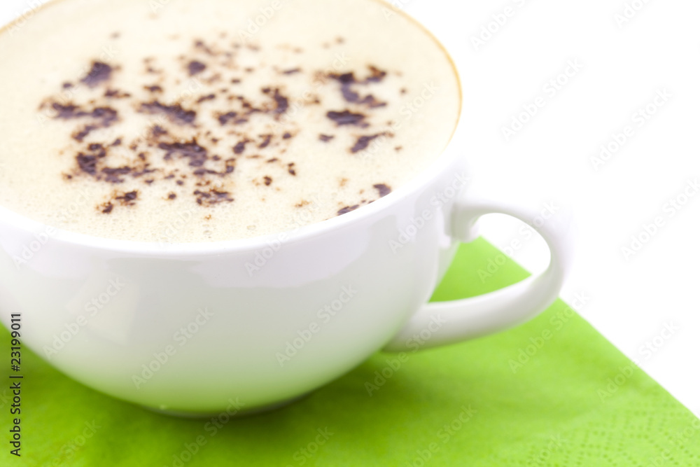 Obraz premium Cappuccino on the green cloth isolated on white