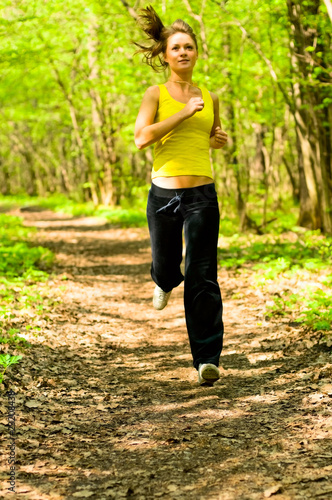young woman running in forest