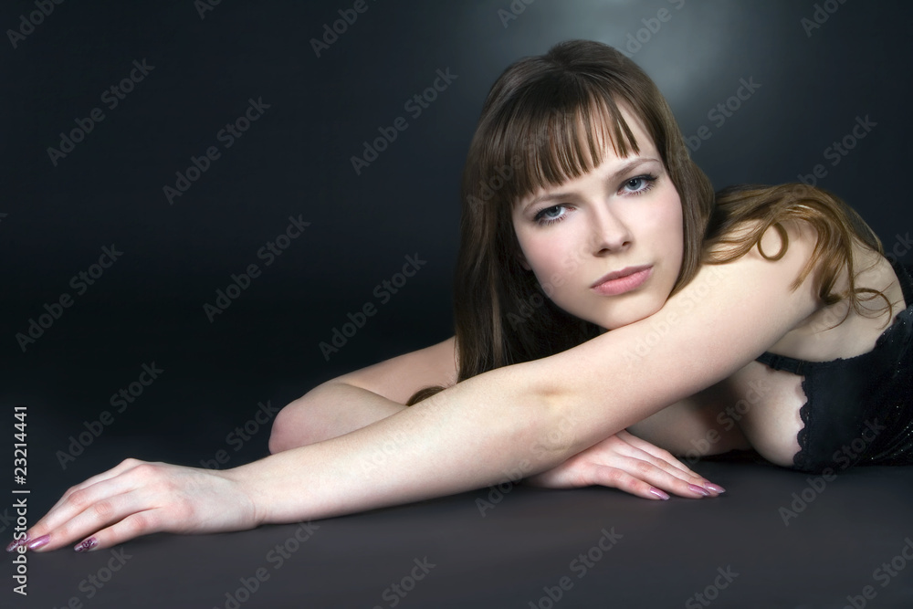 Beautiful brunette girl posing in studio on dark background Beautiful brunette girl posing in studio on dark background