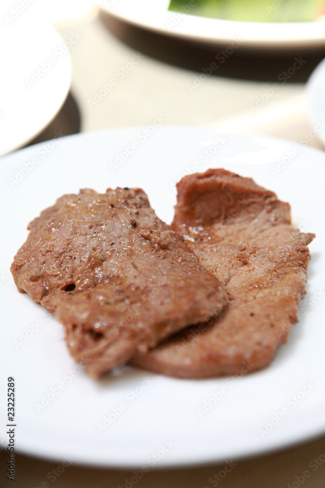 a steak with in a white plate a steak with in a white plate