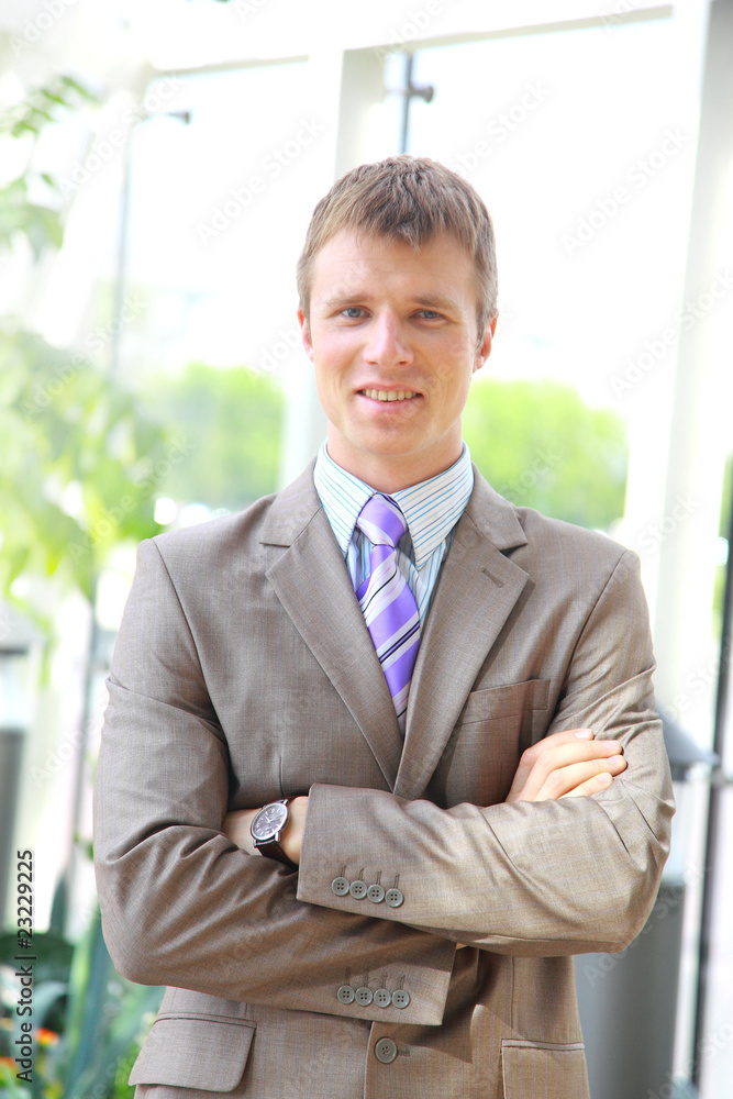 businessman standing with hands in pocket in front of windows businessman standing with hands in pocket in front of windows