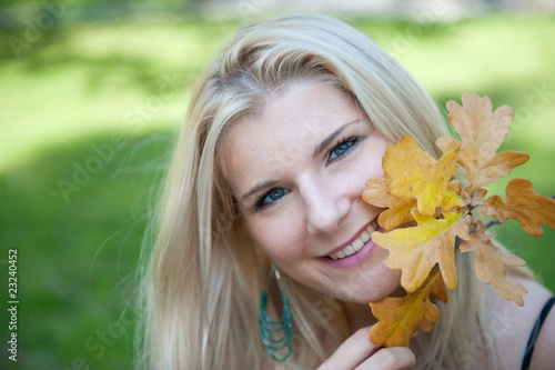 young pretty autumn woman outdoors smiling  with yellow leafs