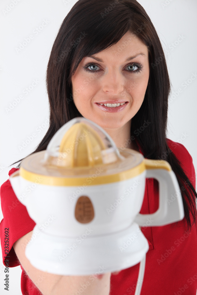 Jeune femme avec un presse-citron électrique Jeune femme avec un presse-citron électrique