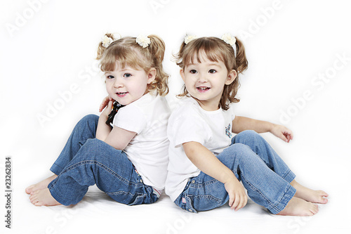 Adorable little twin girls isolated on white background