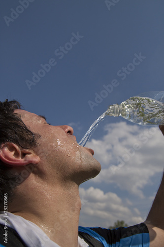 sportler spritzt wasser ins gesicht