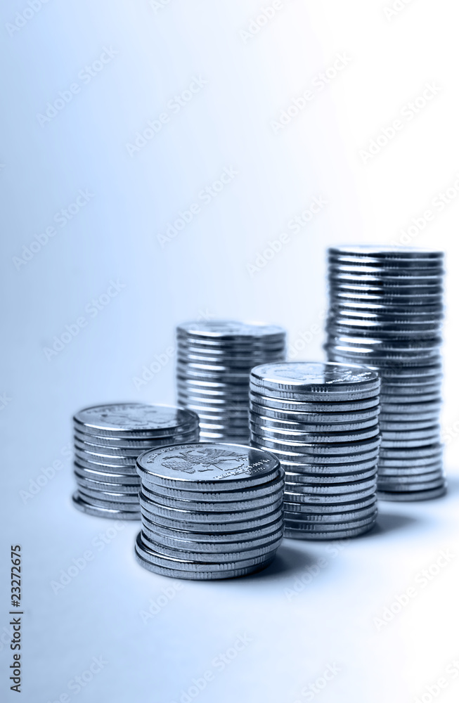 pile of blue toned metallic coins on a light background pile of blue toned metallic coins on a light background