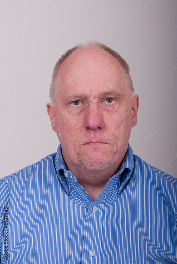 Older Balding Man in Blue Shirt Looking Unhappy Older Balding Man in Blue Shirt Looking Unhappy