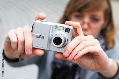The girl holds the camera in hands