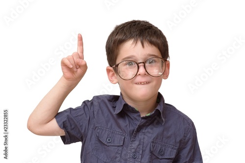 Little boy in funny round spectacles raising finger