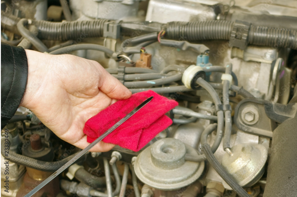 Fototapeta premium Checking engine oil dipstick in the car