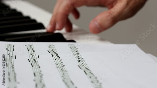 Hand playing music notes on piano