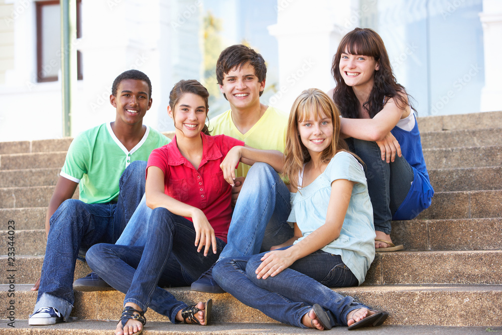 Obraz premium Group Of Teenage Friends Sitting On College Steps Outside