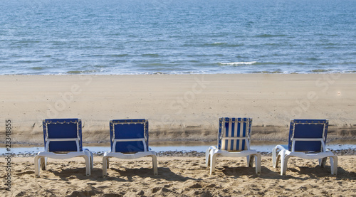 four blue reclining sun loungers over looking the sea