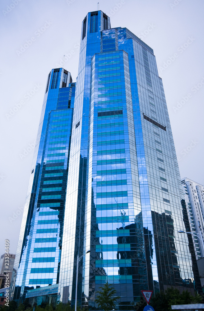 Naklejka premium Highrise glass building with sky and clouds reflection
