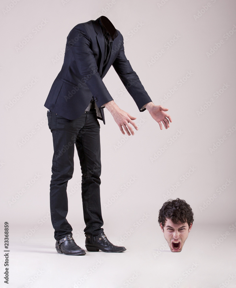 Headless business man searches his head. Stock Photo Adobe Stock