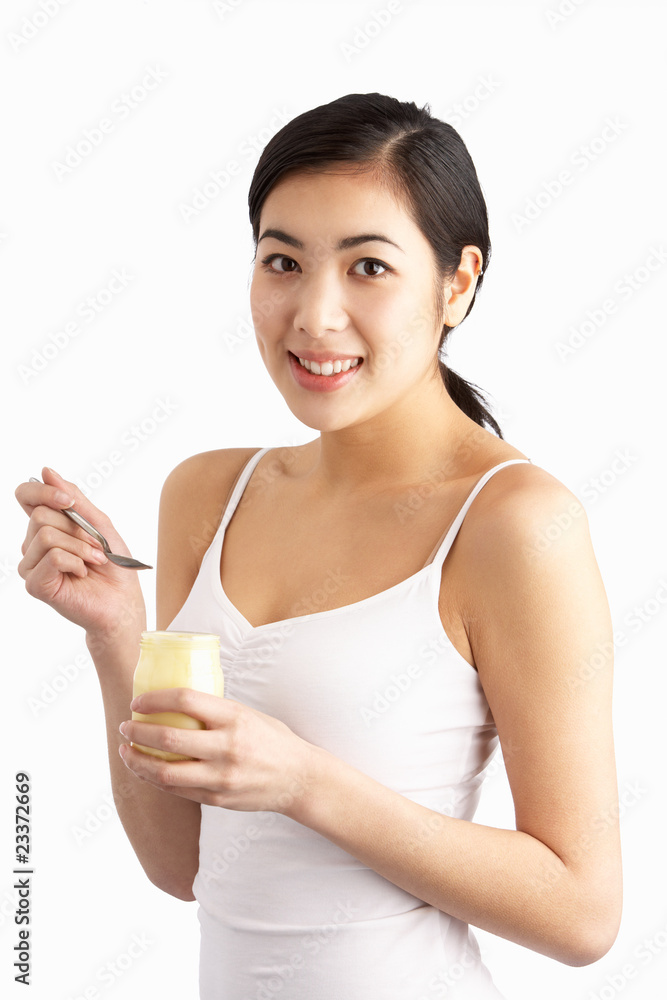 Young Woman Eating Yoghurt In Studio Young Woman Eating Yoghurt In Studio