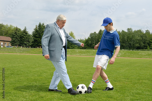 älterer Mann und junger Mann spielen Fussball