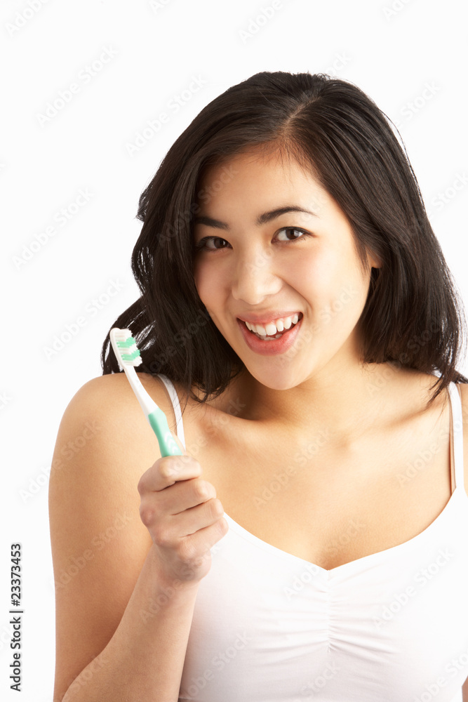 Young Woman Brushing Teeth In Studio Young Woman Brushing Teeth In Studio