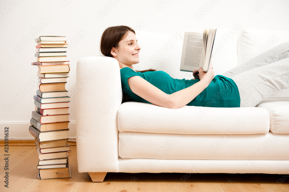 junge frau liest auf sofa buch junge frau liest auf sofa buch