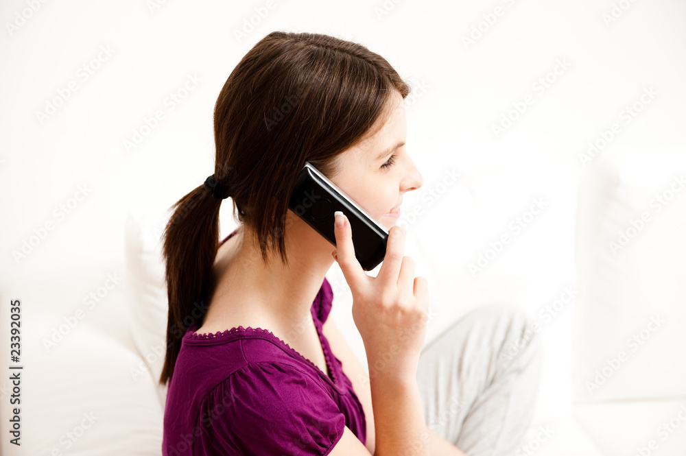 junge frau sitzt auf sofa und telefoniert, lacht junge frau sitzt auf sofa und telefoniert, lacht