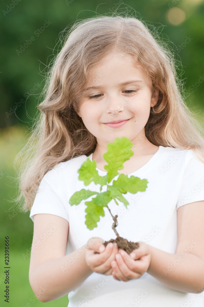 Obraz premium Little girl and young oak tree