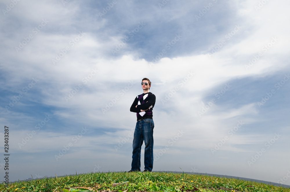 young man in the clouds on the green grass young man in the clouds on the green grass