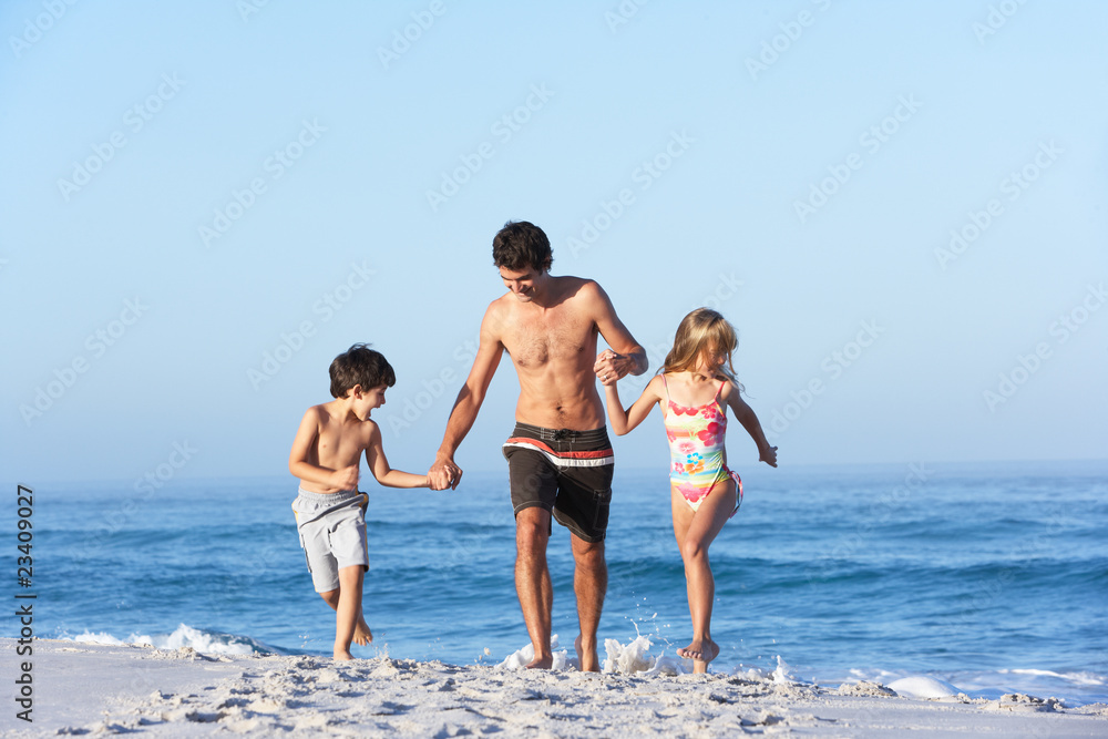 Father Running With Children Along Sandy Beach Father Running With Children Along Sandy Beach