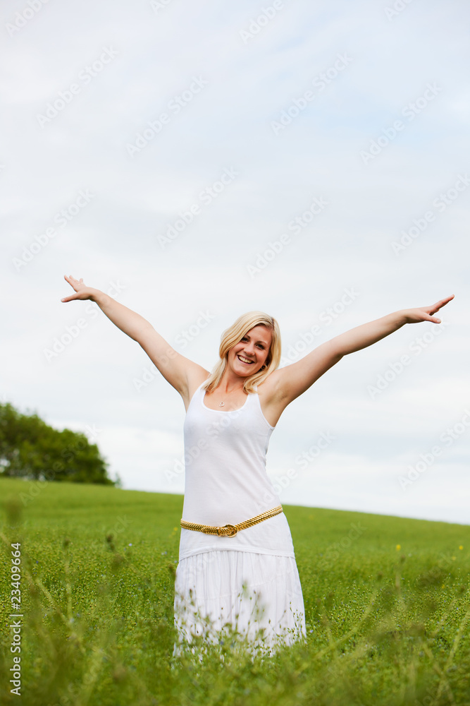 Young woman in field arms outstretched with joy Young woman in field arms outstretched with joy