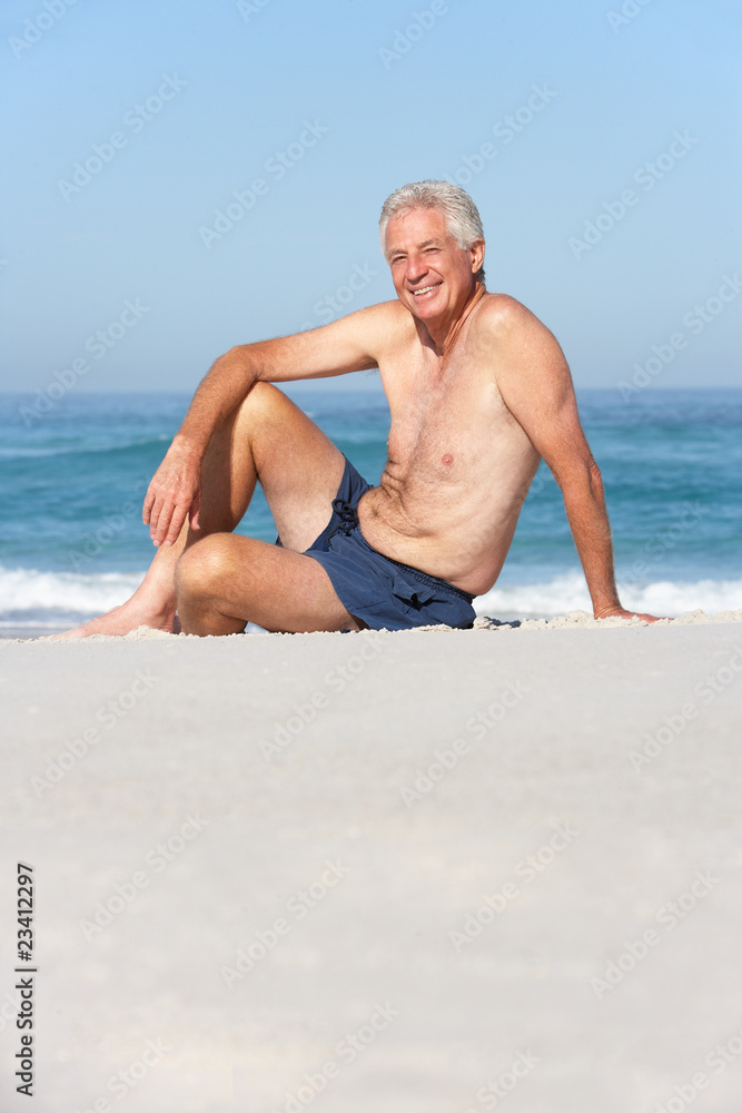 Senior Man On Holiday Sitting On Sandy Beach Senior Man On Holiday Sitting On Sandy Beach