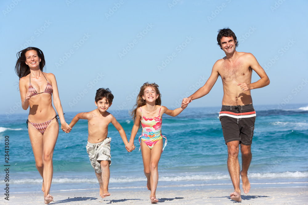 Young Family Running Along Beach on Holiday Young Family Running Along Beach on Holiday