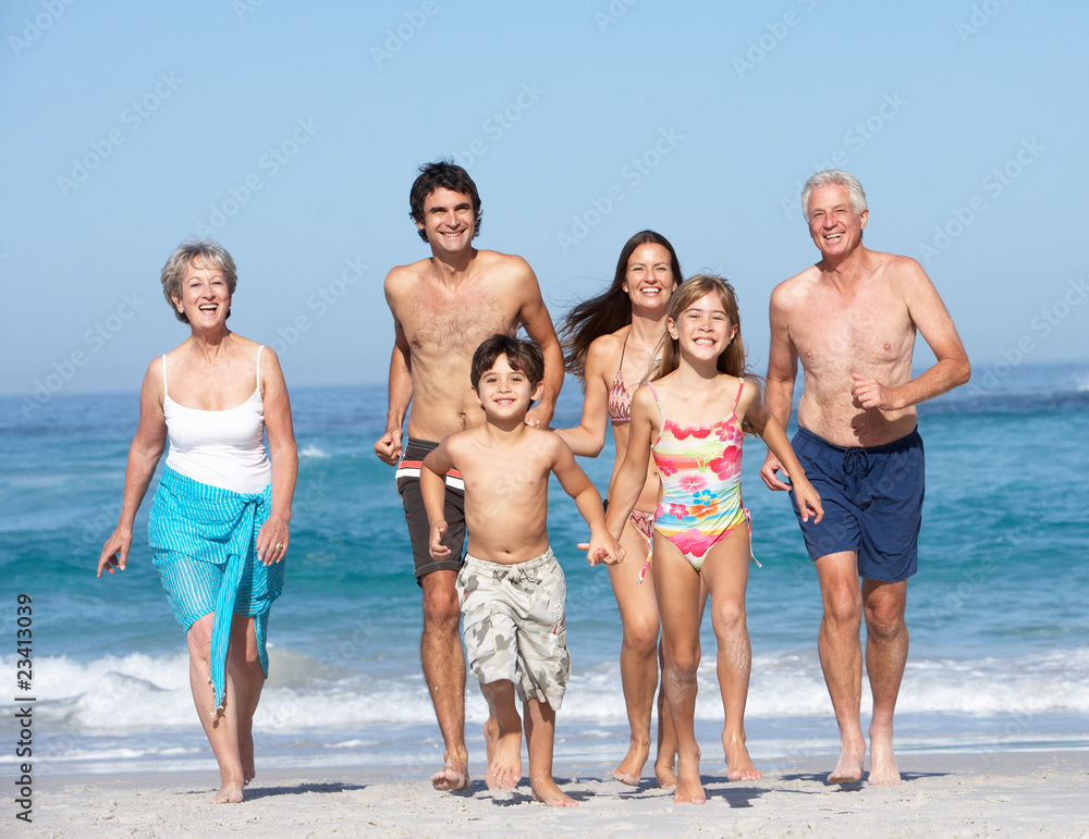 Three Generation Family On Holiday Walking Along Beach Three Generation Family On Holiday Walking Along Beach