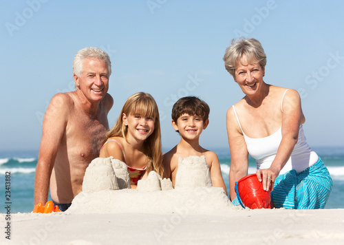 Grandparents And Grandchildren Building Sandcastles Together On