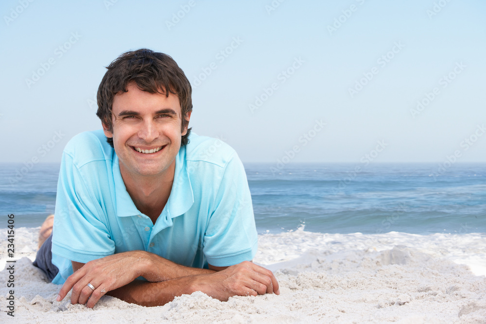 Young Man Relaxing On Sandy Beach