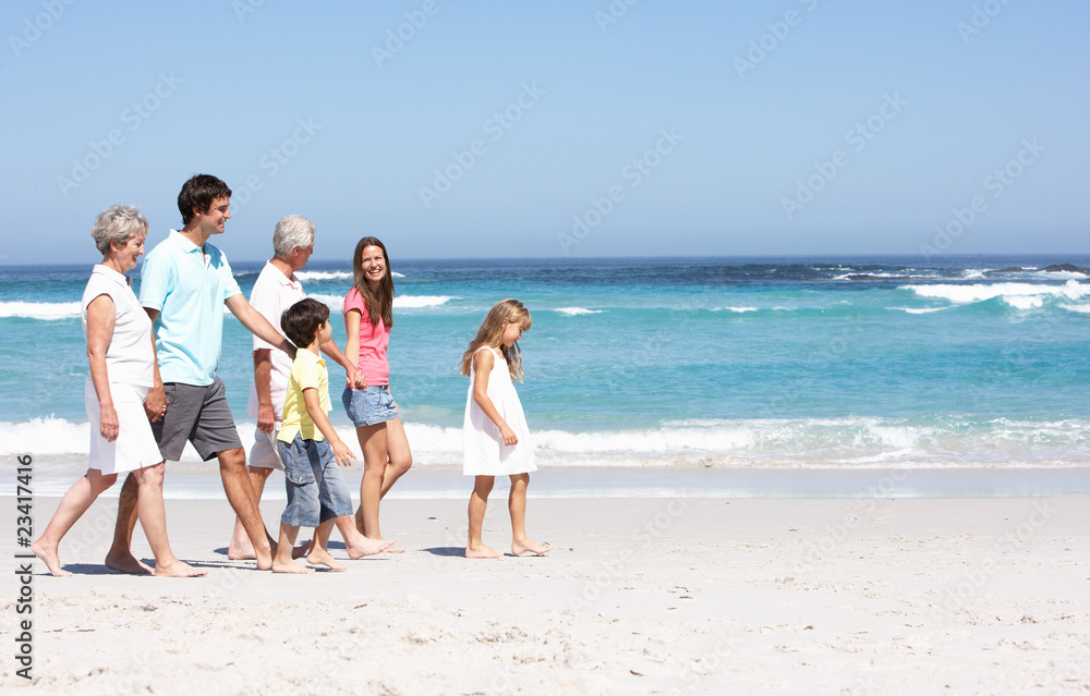 Three Generation Family Walking Along Sandy Beach Three Generation Family Walking Along Sandy Beach